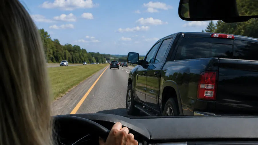 Driver on a freeway noticing an intuitive warning while another vehicle begins merging into their lane, representing Energy Hygiene, personal frequency, and intuitive awareness.